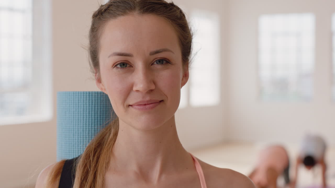 ritratto bella donna caucasica yoga sorridente con fiducia godendo di uno stile di vita sano con persone che praticano in palestra di fondo