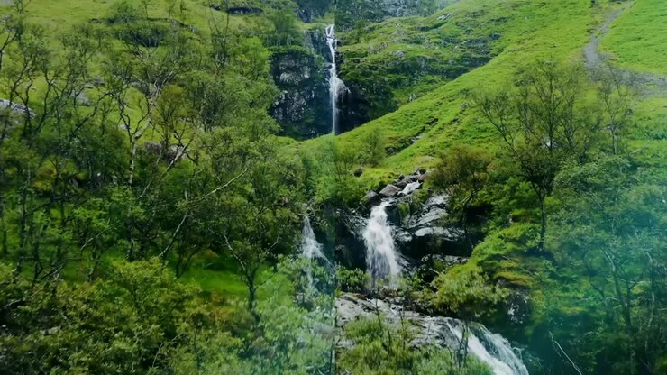 Scenic Waterfall in a Lush Forest and Historical European Building
