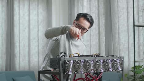 hombre asiático con gafas arreglando la plataforma de minería para la minería de criptomoneda