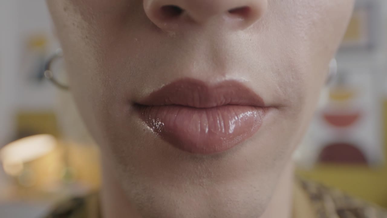 una toma detallada y cercana que captura la belleza y la elegancia de una mujer después de aplicar hábilmente lápiz labial, mostrando el arte y la precisión de su rutina de maquillaje