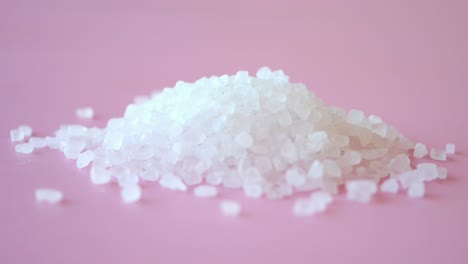 cerca de una pila de sal blanca en un fondo rosado