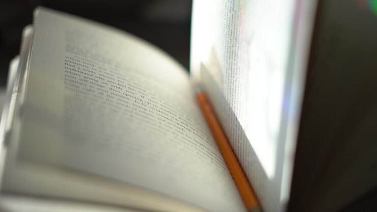 Matita usata come segnalibro in un libro con copertina rigida - primo piano con messa a fuoco centrale e profondità di campo ridotta.