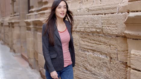 young woman walking through an alley in town