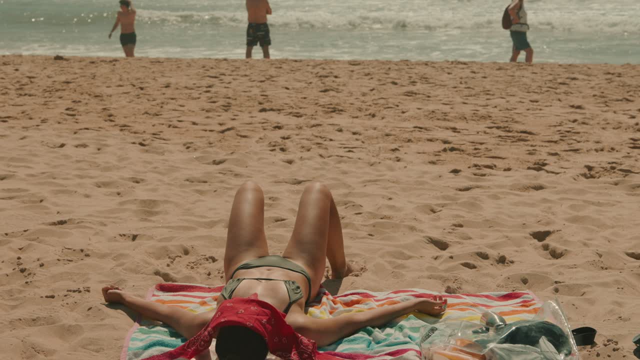 женщина загорает на пляже.