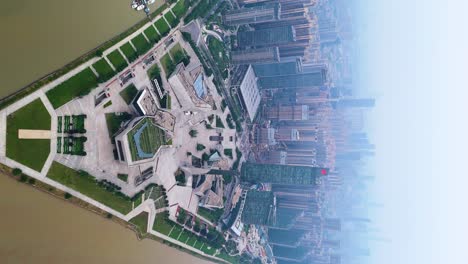 Vertical-aerial-revealing-shot-of-the-low-lying-smog-over-downtown-Changsha,-China-next-to-the-Xiang-River