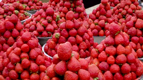 piles of strawberries arranged in bowls at a papua new guinea market