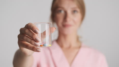 doctora caucásica con un frasco con pastillas.