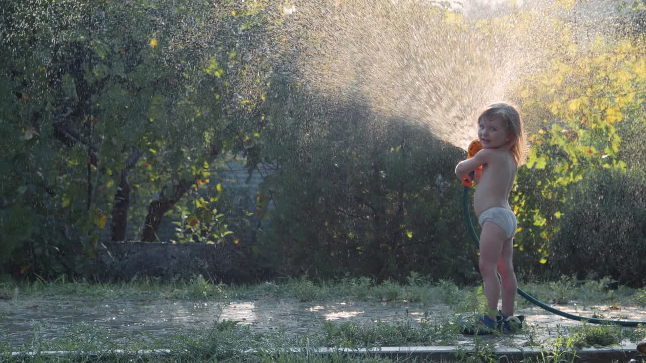 Child Playing with Hose in Garden