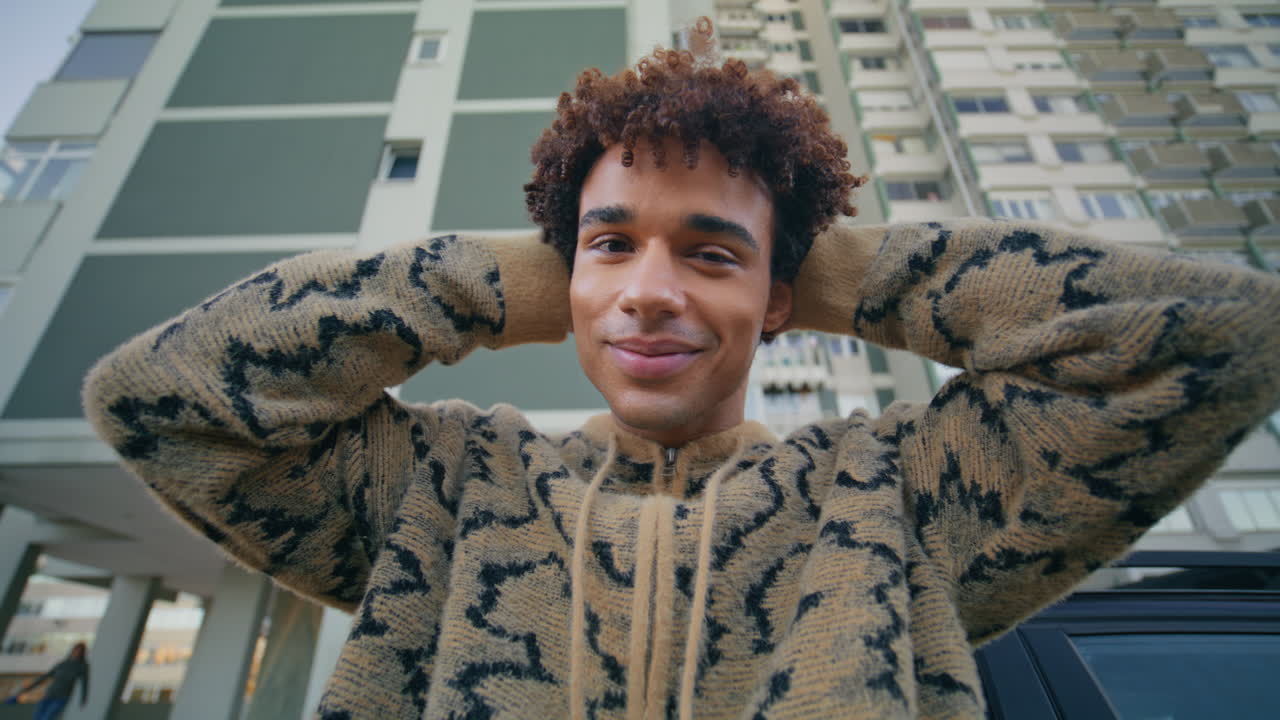 Man model standing street leaning on luxury auto closeup. Smiling latino guy