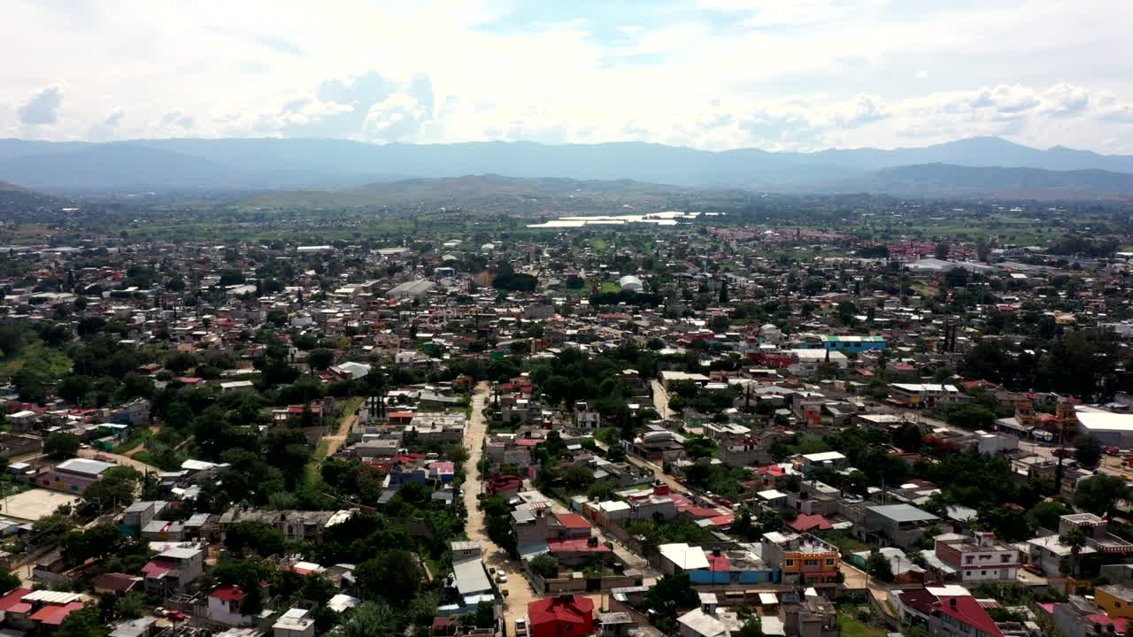 vista aérea de los suburbios de la ciudad de oaxaca en méxico, filmada por un dron con desplazamiento horizontal y horizonte de fondo