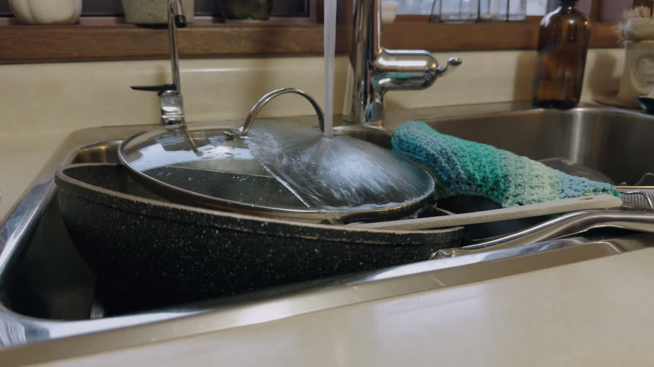 Kitchen Tap Water Running Over Dirty Dishes In Sink