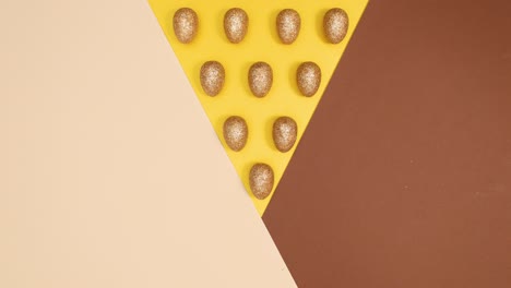 los huevos de glamour dorados de pascua aparecen en un fondo desnudo dorado.