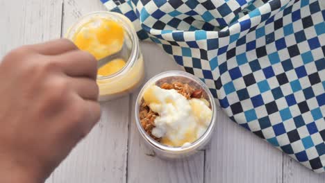poniendo yogur en granola musli en un tazón