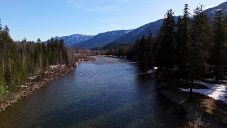 Scenic-forward-shot-of-river-and-mountain-range-in-background-in-Cle-Elum-on-a-clear-day-in-Washington-State