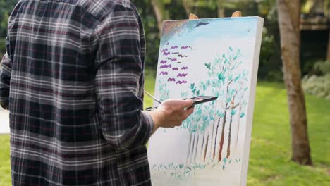 man painting on canvas in the garden 4k