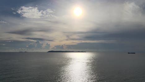 Aerial-view-of-low-setting-sun-reflecting-on-calm-sea