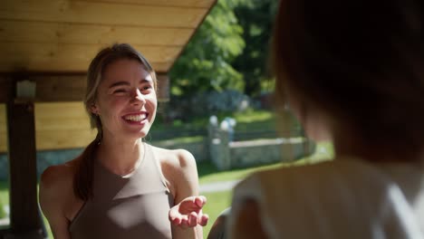 First-person-view-two-blonde-girls-sit-in-a-gazebo-and-communicate-in-nature.-Rest-in-the-green-forest-on-a-sunny-day