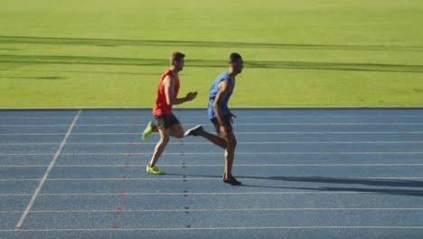 two athletes running in stadium