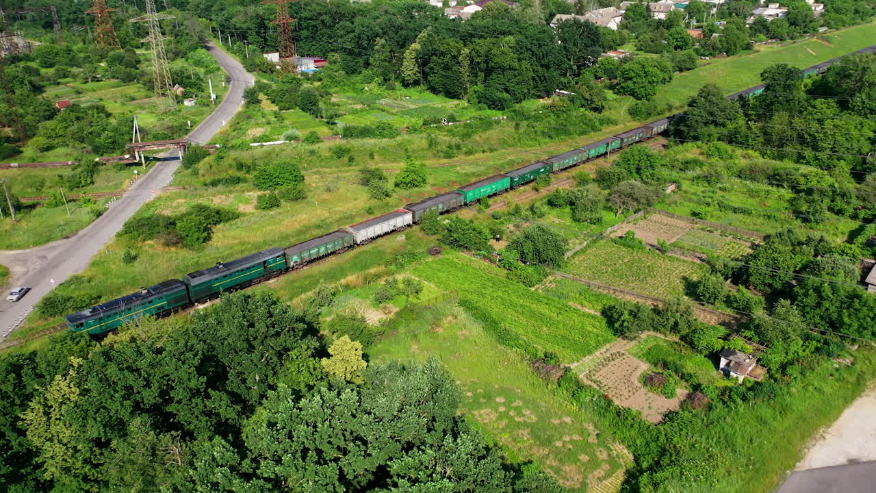 Aerial view of cargo train. Aerial view from above of railroad through green forest