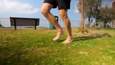 hombre mayor con barba corriendo cerca de la orilla del mar