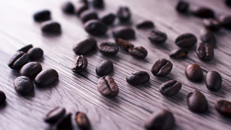 Toma-Panorámica-Lenta-De-Granos-De-Café-Tostados-Sobre-Una-Superficie-De-Madera.