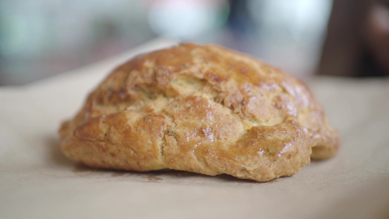 Hand Picking Up Freshly Baked Pastry From Parchment Paper