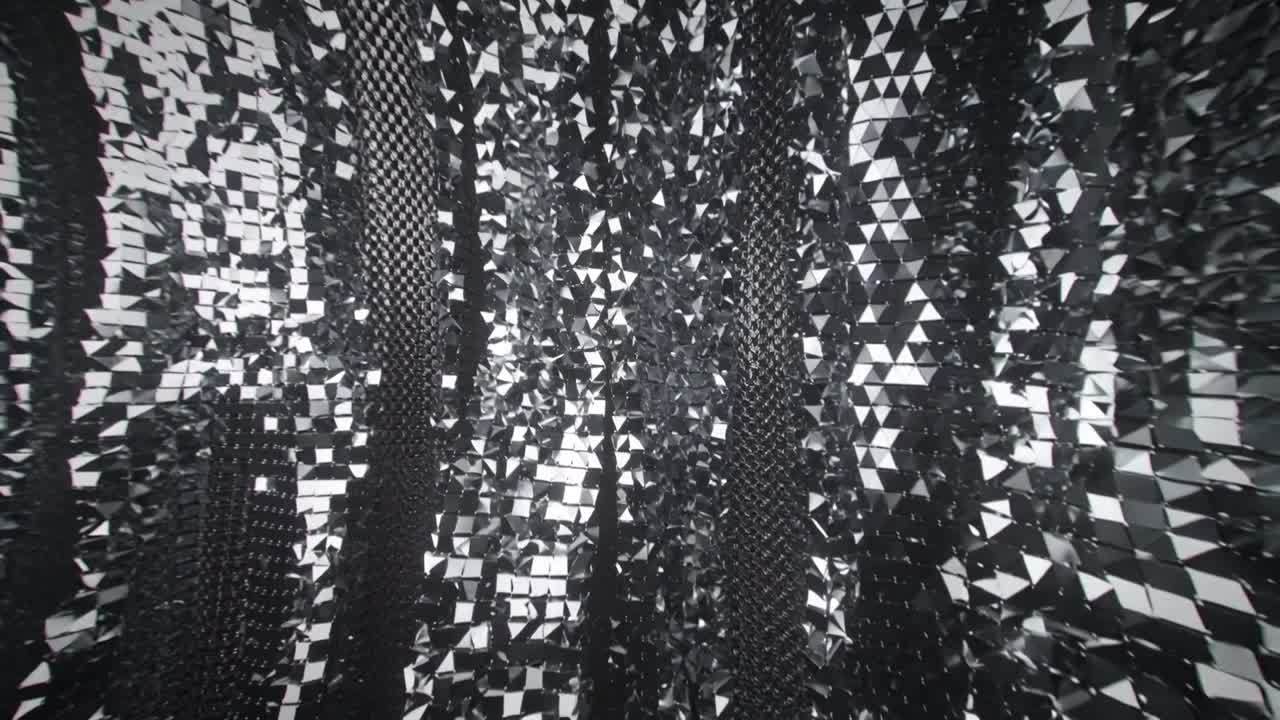 La telecamera in movimento rivela una superficie riflettente sfaccettata che si increspa in un mosaico a scacchiera in un vuoto scuro.