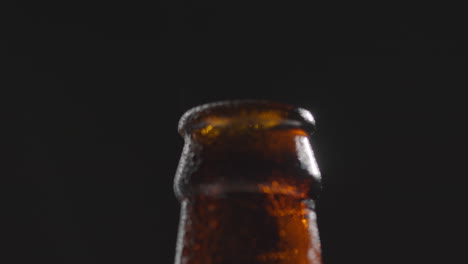 cierre de gotas de condensación en el cuello de la botella de cerveza fría o bebida gaseosa con vapor de agua después de la apertura