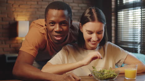 positive multiethnic couple talking on web call at home