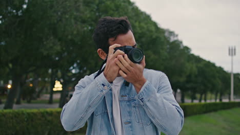 turista hispano haciendo fotos parque de la ciudad de cerca. viajero despreocupado disparando
