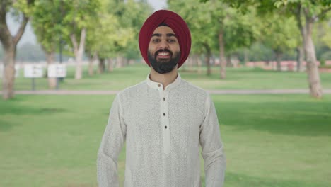 happy sikh indian man giving flying kisses in park