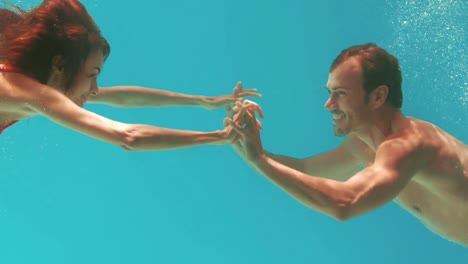 happy couple swimming underwater