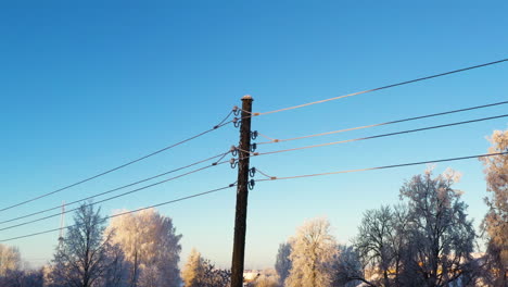 Hoarfrost-on-power-lines-on-cold-winter-morning-on-blue-sky-background