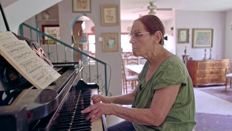 old woman playing a grand piano at her home