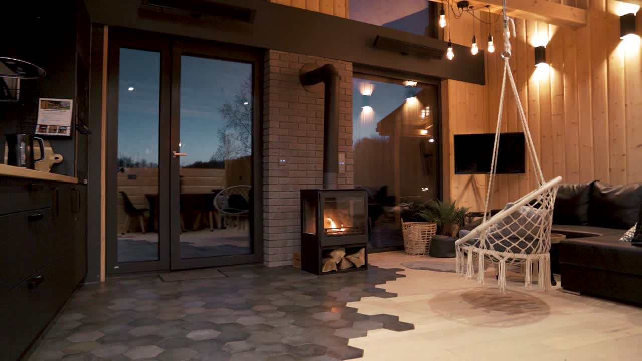 acogedor y moderno interior de cabaña de madera con chimenea por la noche