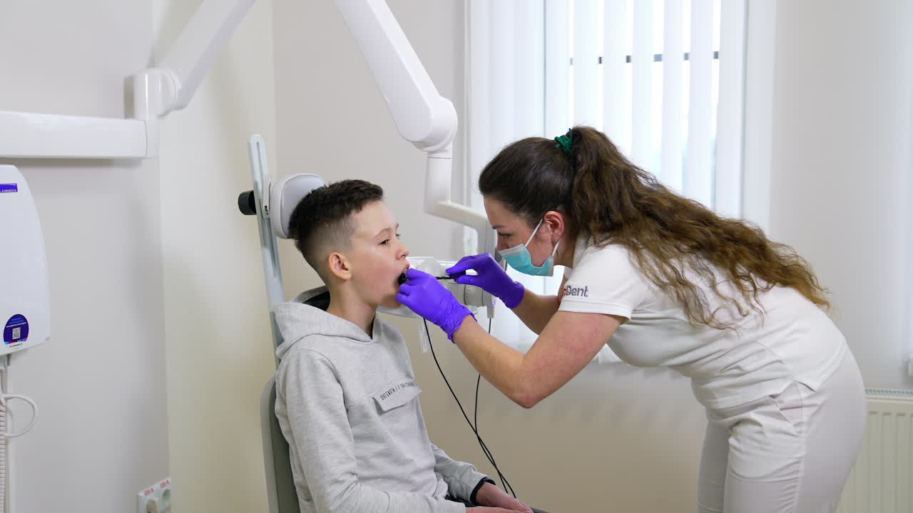Giovane ragazzo in visita dal dentista in ospedale. Un bambino controlla lo stato dei denti in odontoiatria.