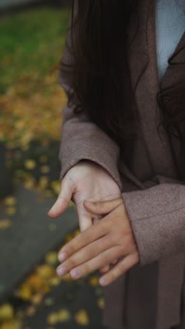 mujer con las manos juntas en el parque de otoño