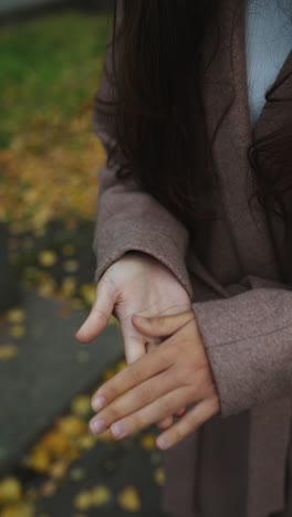 woman with hands clasped in autumn park