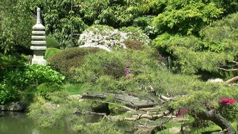 una pagoda de piedra y un puente peatonal en un jardín japonés