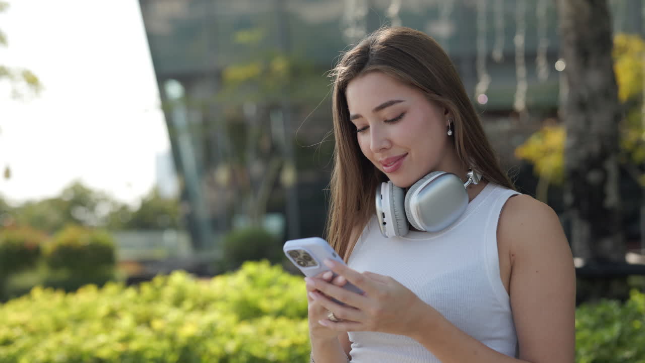 Giovane donna che utilizza il telefono cellulare all'aperto