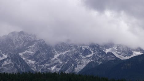 Rugged-Mountain-Ridges-Covered-With-Snow-Against-Cloudy-Sky