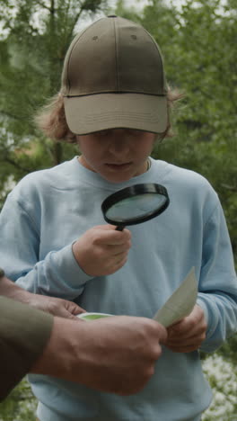child using a magnifying glass and map outdoors
