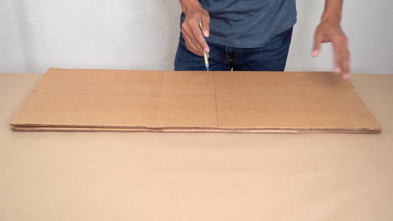 Mani che lavorano il cartone in un momento creativo e di concentrazione in interni