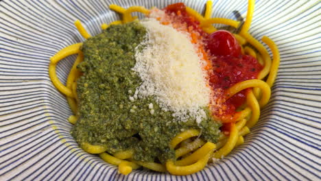 Pasta-Tradicional-Recién-Hecha-Con-Pesto-Verde,-Salsa-De-Tomate-Y-Queso-Parmesano,-Comida-Italiana,-Toma-De-4k