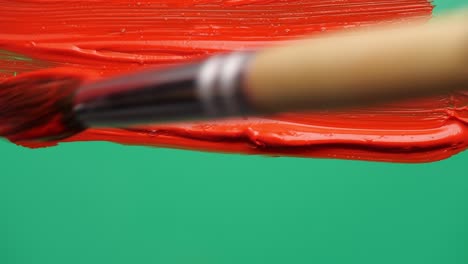 brush paints a green screen. close up.