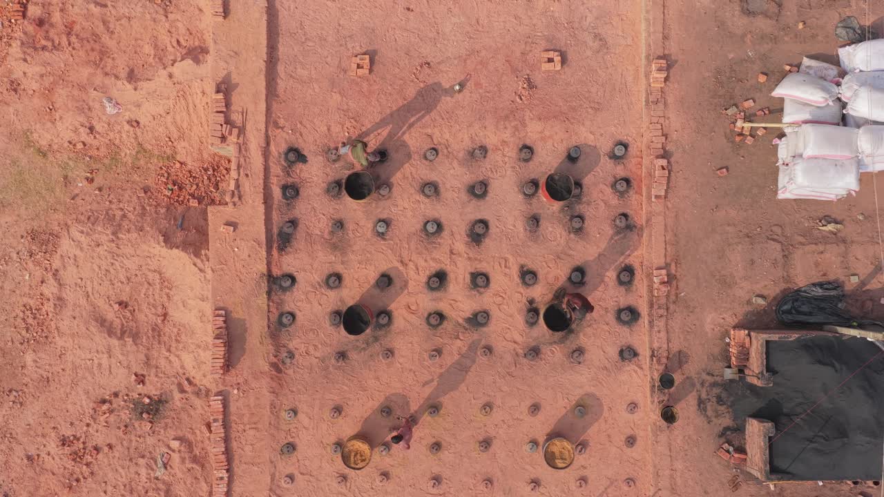 Video con drone di un sito di produzione di mattoni con fumo e operai in Bangladesh