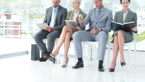 Business-people-looking-at-notebook-and-smartphone