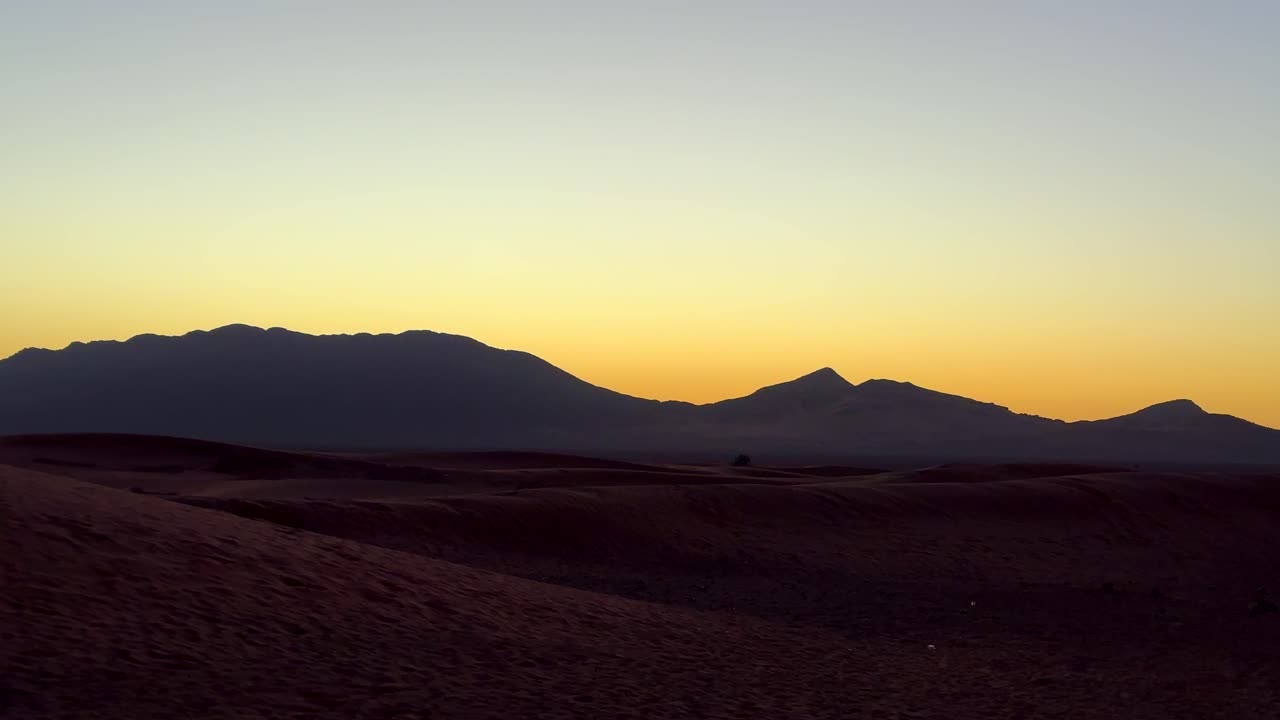 dunas de arena y montañas en el desierto del sahara en el norte de áfrica al amanecer