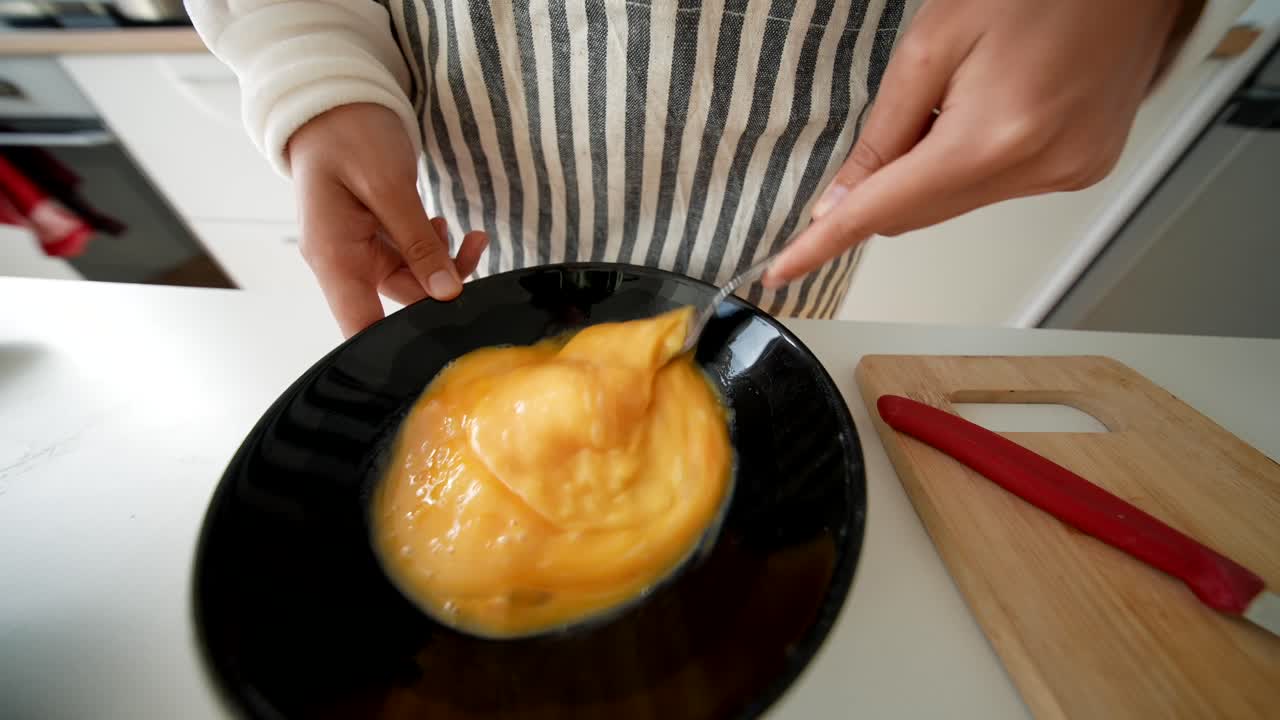 Primo piano di mani che mescolano uova crude in una ciotola