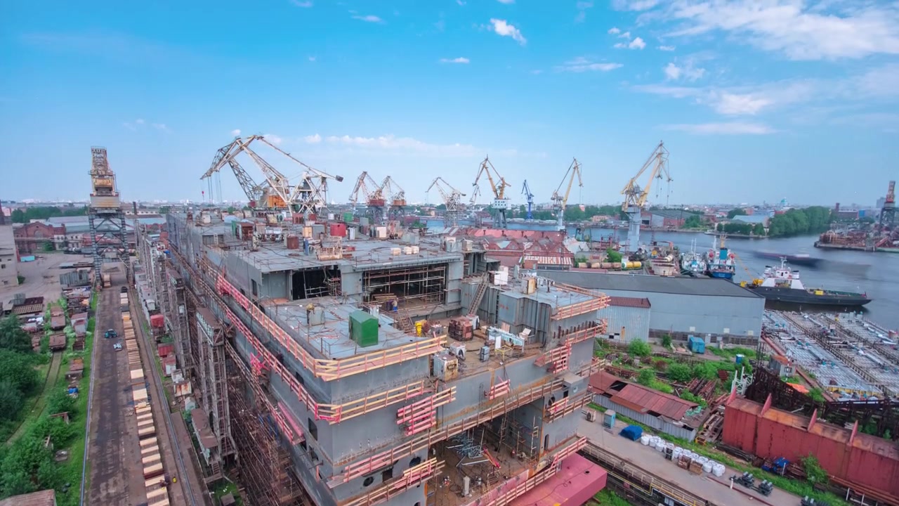 船廠內大型船舶建造的縮時攝影，起重機林立。工廠車間內船體的一個片段。從上方俯瞰組裝中的金屬框架。